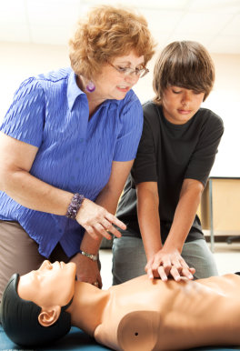woman teaching the boy how to do CPR